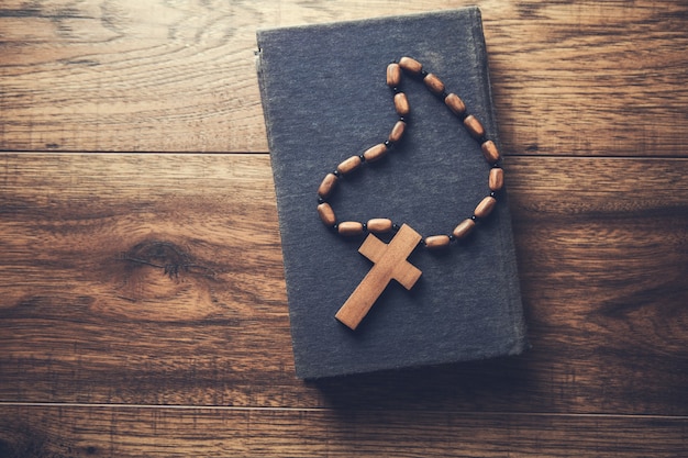 Wooden cross on the Bible on the table