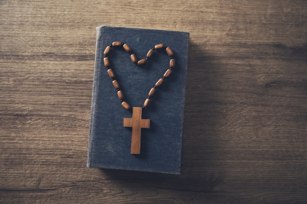 Деревянный крест на Библии на столе