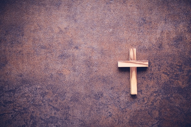 Photo wooden cross on dark copy space toning background