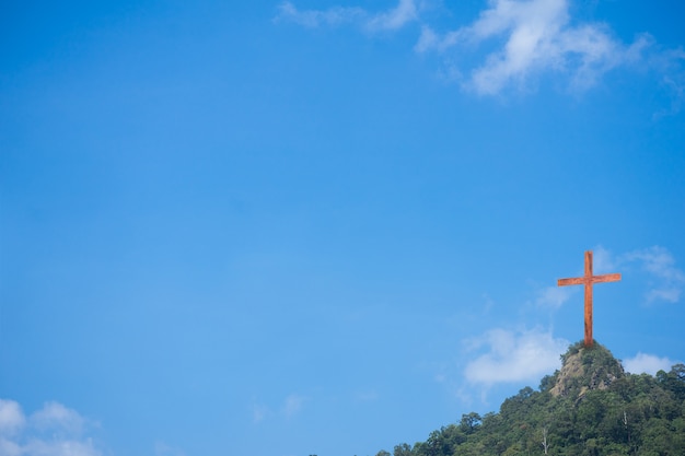 wooden cross on the mountain and blue sky background