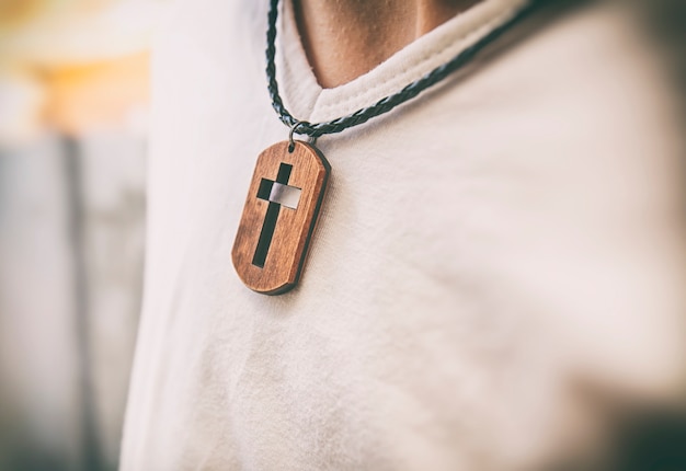 The wooden cross necklace on man's neck