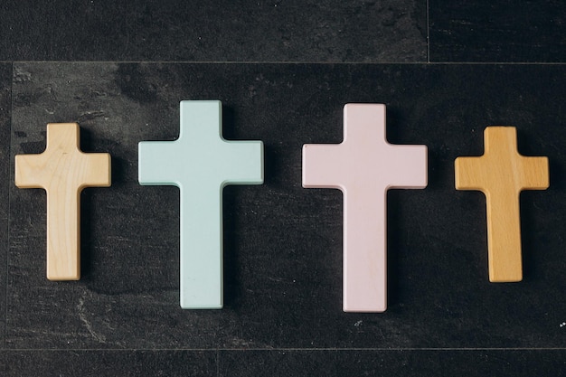 Wooden cross on a new black plastered brick wall Concept of Religion Many crosses