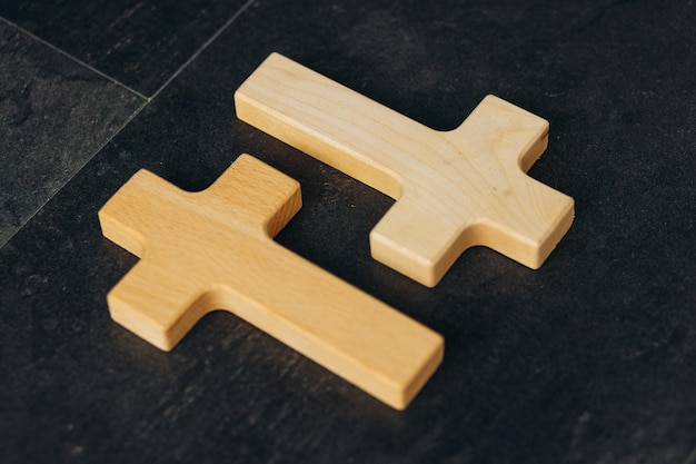 Wooden cross on a new black plastered brick wall Concept of Religion