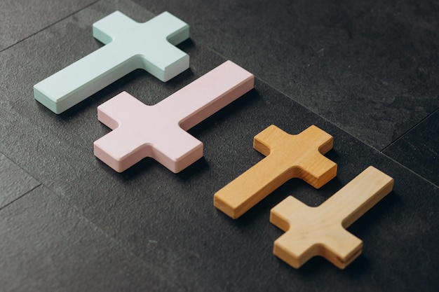 Wooden cross on a new black plastered brick wall Concept of Religion