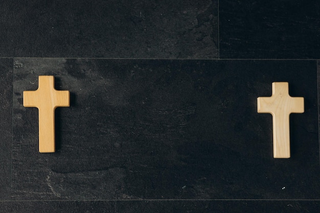 Wooden cross on a new black plastered brick wall Concept of Religion