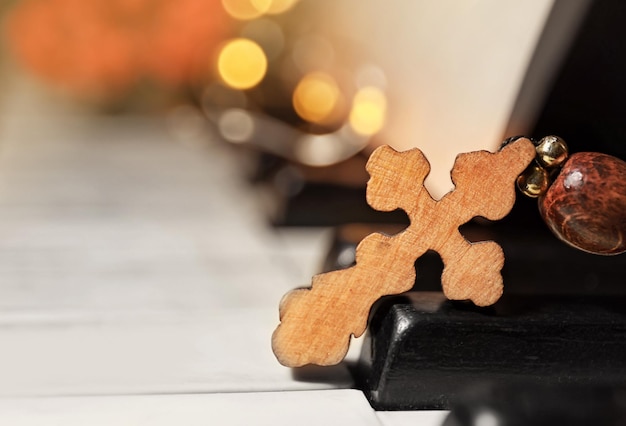 Wooden cross on piano keys, closeup