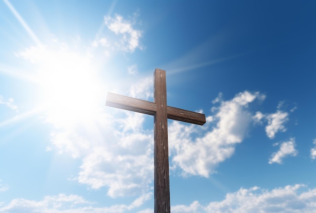 Photo a wooden cross standing on a blue sky with sunlight