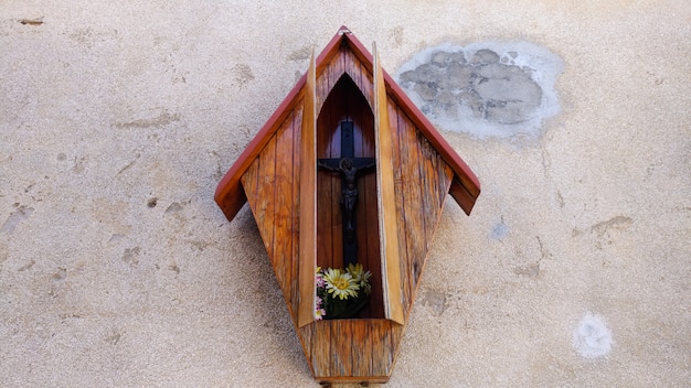 Wooden cross on stone brick wall in box