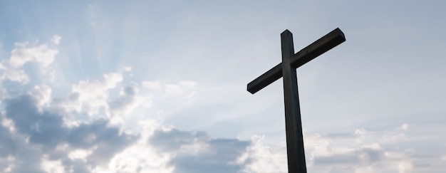 Wooden cross over sunrise background