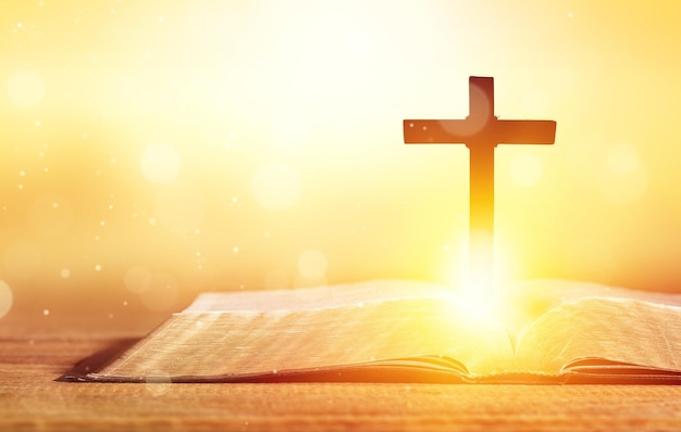 Wooden cross with a crucifix on the background of the holy bible