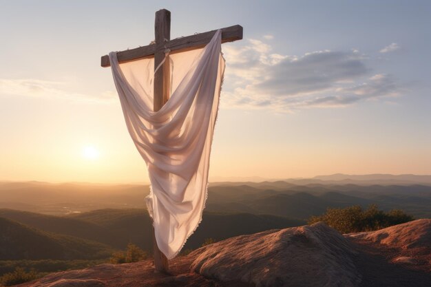 Wooden cross with white scarf at sunrise on rocks Easter and crucifixion theme