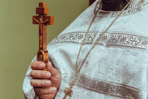 Wooden crucifix in the hand of the priest