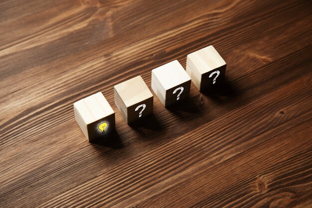Wooden cube block with question mark symbol and light bulb icon