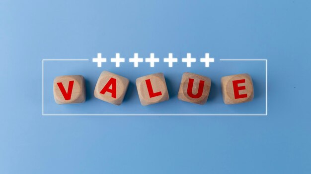 青い背景のValueビジネスワードとプラスアイコンの木製の立方体ブロック ミッションビジョンとコア・バリューズコンセプト