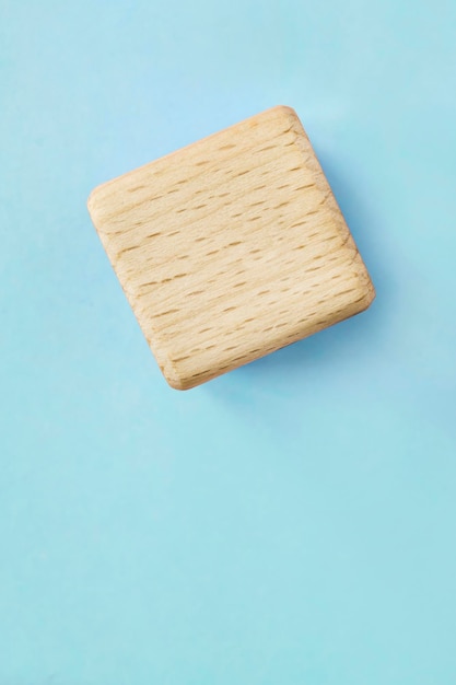 Wooden cube on blue background