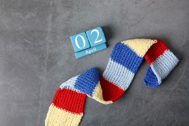 Wooden cube calendar with autism colors knitted scarf April 02 nd Autism Awareness concept Top view