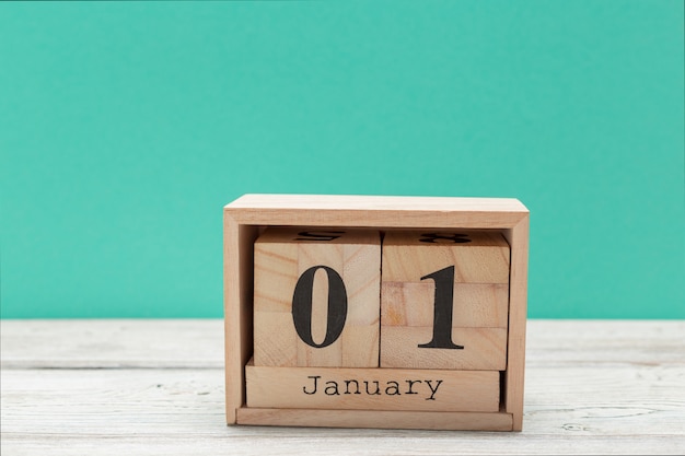 wooden cube shape calendar for january 1 on wooden tabletop