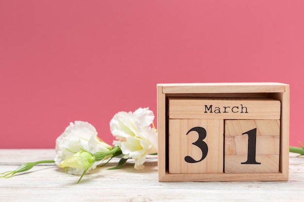 wooden cube shape calendar for march 31 on wooden tabletop