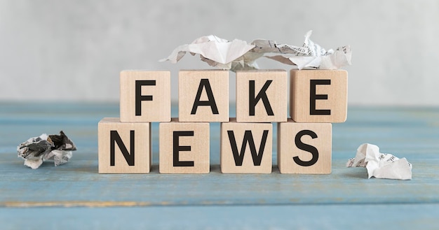 Деревянный куб с флип-блоком FAKE to FACT Новостное слово на фоне стола Новостное решение