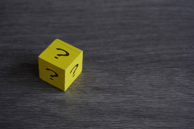 Wooden cube with question mark on table with copy space Concept of luck risk and choice