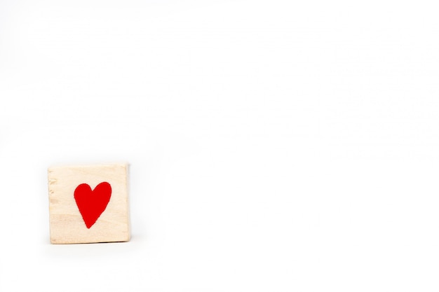 Wooden cube with a red heart symbol isolated