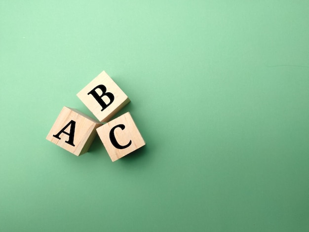 Wooden cube with text ABC on green background