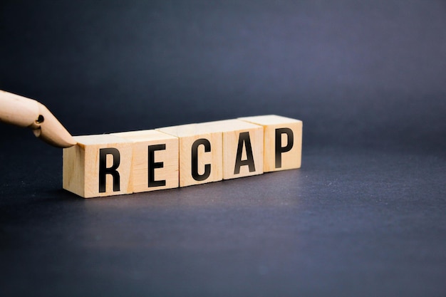 写真 「recap」という言葉が書かれた木製の立方体、これまでに言われたことの要約、フラッシュバックの概念