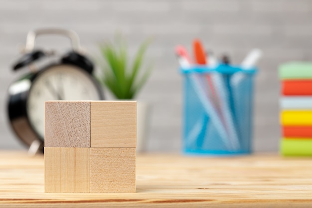 Wooden cubes and alarm clock on desk