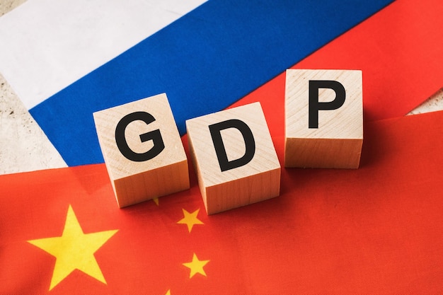 Wooden cubes on the background of flags concept on the topic of comparing GDP of Russia and China