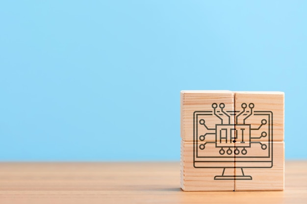 Wooden cubes on blue background with icon of software app application development api concept