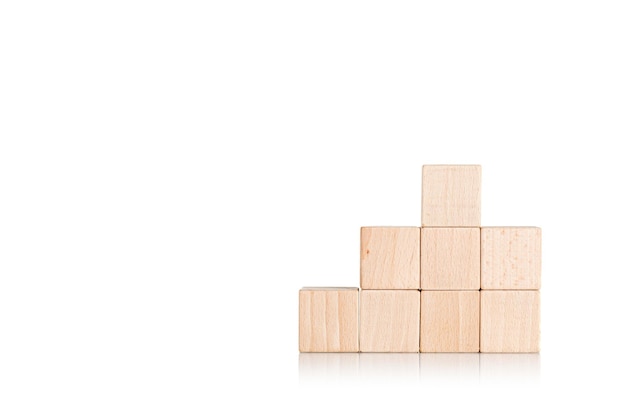 Photo wooden cubes in the form of a ladder with a hand on an isolate white background closeup