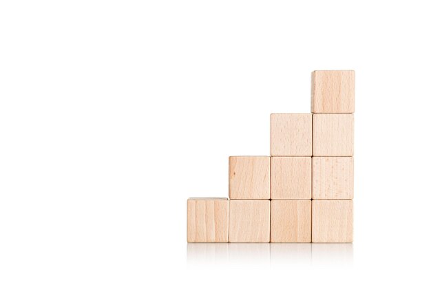 wooden cubes in the form of a ladder with a hand on an isolate white background closeup