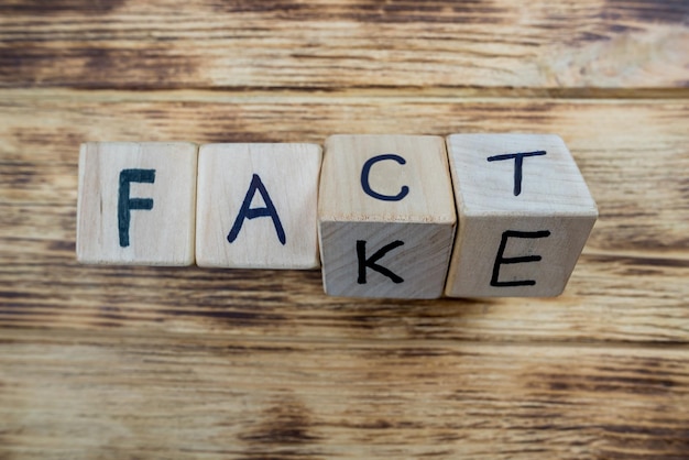 Wooden cubes form the words fact and fakeCloseup of cubes on wooden background