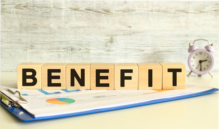 木製の立方体は、灰色の背景に財務チャートのあるフォルダーにあります。キューブはBENEFITという言葉を構成します。