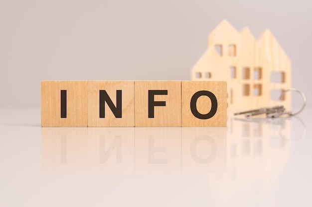 wooden cubes on a table with text INFO model house and keys on background