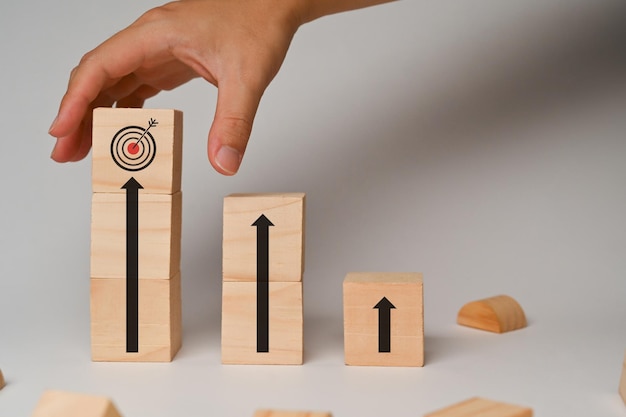 Деревянные кубики с стрелками и иконками целей Увеличение эффективности бизнеса и концепций бизнес-целей