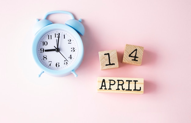 古いピンクの4月14日の日付を持つ木製の立方体。