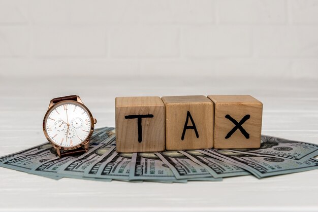 Cubi di legno con banconote in dollari e orologio da polso