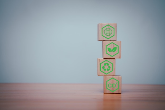 Wooden cubes with green net zero icon and green icon on grey background Net zero and carbon neutral concept plastic free earth day world environment day