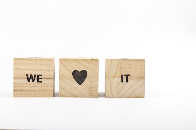 Wooden cubes with the inscription we love it on a white background close up