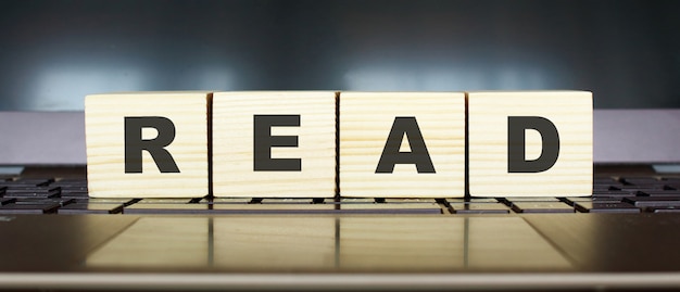 Wooden cubes with letters on a laptop keyboard.