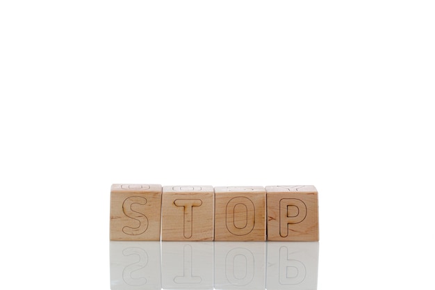 白い背景に文字が止まる木製の立方体