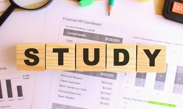 Wooden cubes with letters on the table in the office. Text STUDY