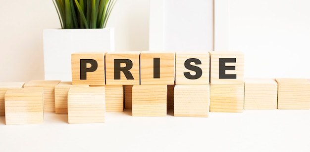 Photo wooden cubes with letters on a white table the word is prise