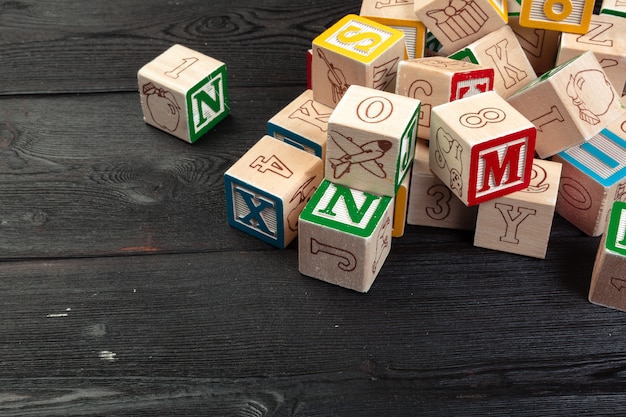 Wooden cubes with letters on wooden background