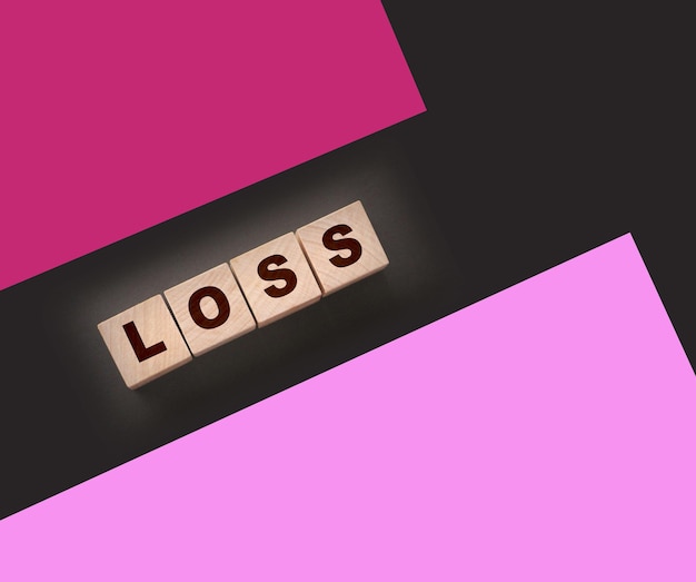 Photo wooden cubes with loss word on blacktable financial loss busines concept