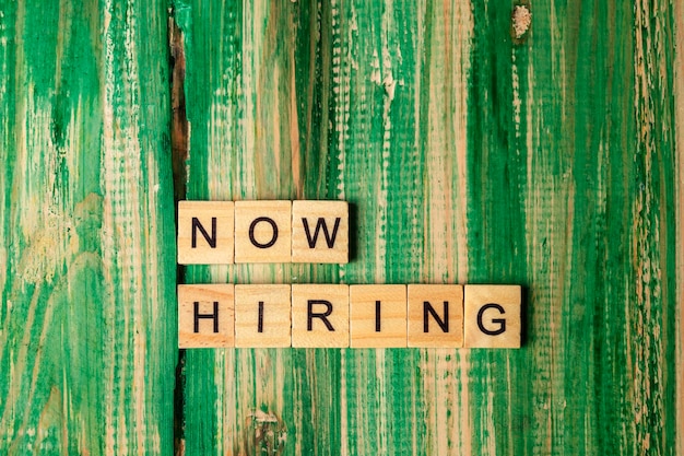 Foto cubi di legno con lettere now hiring