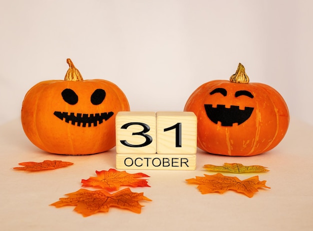 数字 10 月 31 日と白い背景のハロウィーンのお祝いの概念を持つテーブルにカボチャの木製キューブ