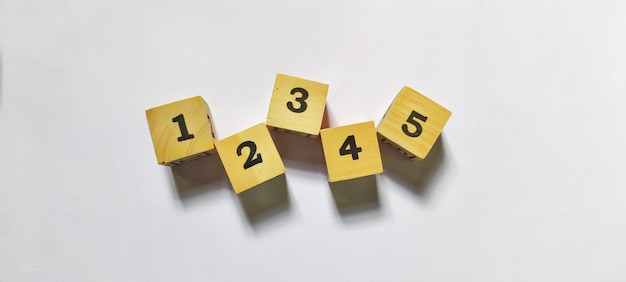 写真 最初、2 番目、3 番目、4 番目、5 番目の数字が付いた木製立方体機会とステップのシンボル
