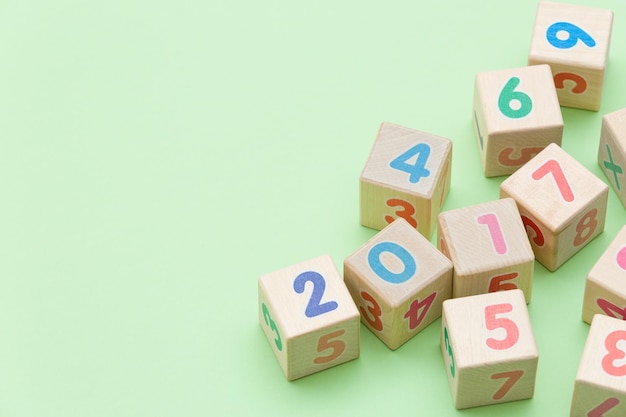 Wooden cubes with numbers on light green background